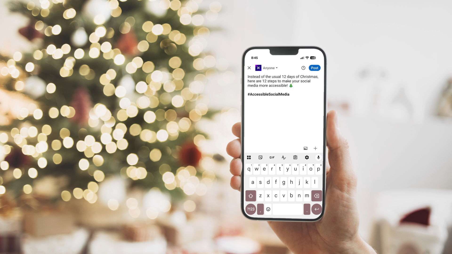 A hand holding a smartphone in front of a blurred Christmas tree with warm lights. On the phone screen, a social media post draft reads: “Instead of the usual 12 days of Christmas, here are 12 steps to make your social media more accessible” followed by the hashtag #AccessibleSocialMedia. The keyboard is visible at the bottom of the screen.