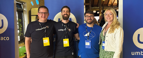 Matt Wise, Danny Lancaster, Rick Butterfield and Amy Czuba stand smiling. They are wearing Codegarden lanyards and standing in front of Umbraco branded roll up banners.