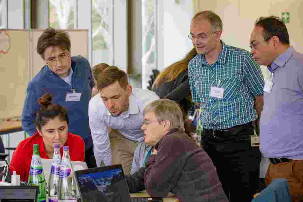 A group of white people around a laptop at the agrifood data hackathon