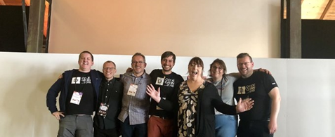The Umbraco accessibilty team at the Codegarden 2019 conference. The group are white people stood in a line against a white wall. They are all smiling and happy.