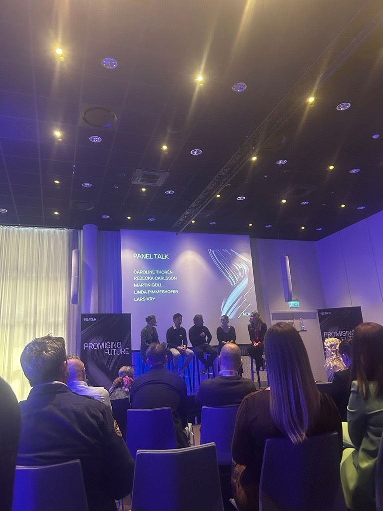 A group of four seated people onstage at the Nexer sustainability summit