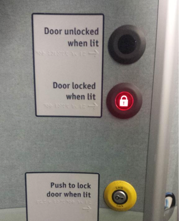 A panel with three buttons. One has text saying "lock", one has a glowing symbol of a lock, and one is unlit. Text beside the unlit button reads "door unlocked when lit", text beside the lit button reads "door locked when lit" and text beside the yellow button reads "push to lock door when lit". Each text is accompanied by braille. 
