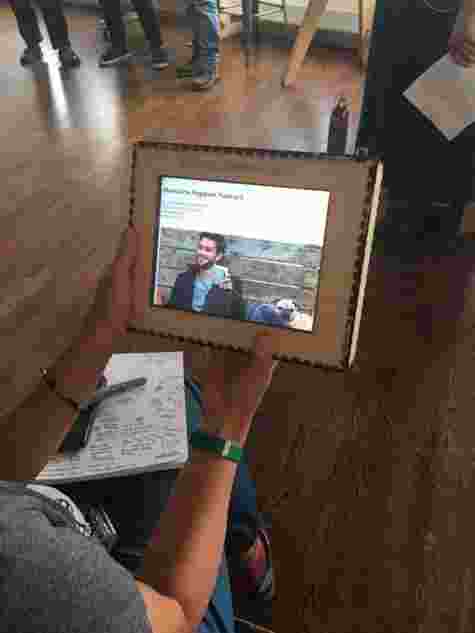 A white woman holding a tablet, with a prototype of a homeless hack solution. 