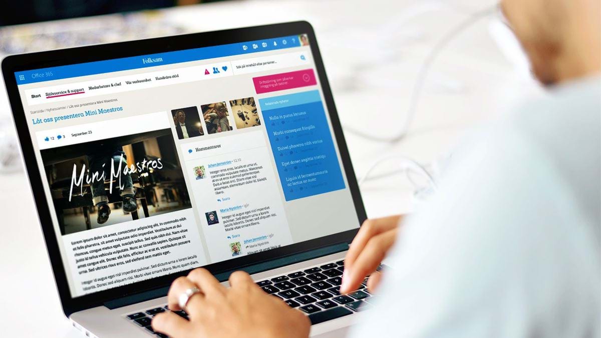 A laptop showing the Folksam intranet with a user's hands on the keyboard