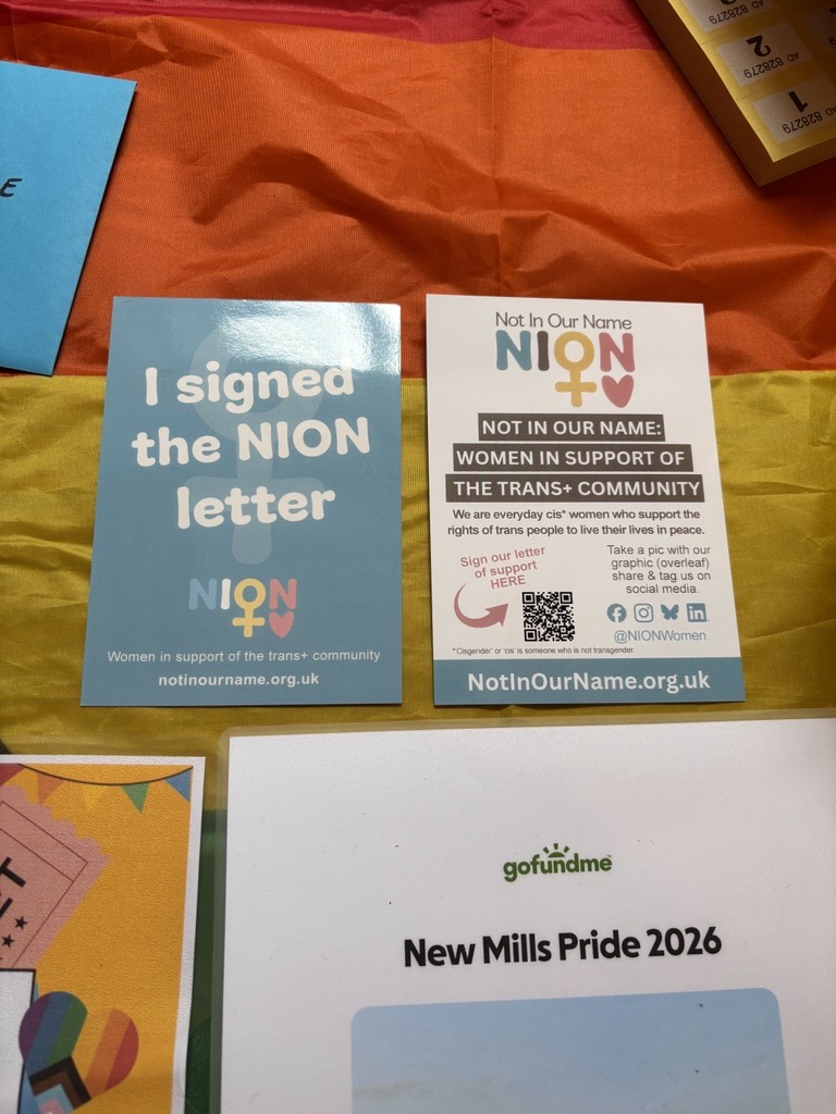 Coloured leaflets arranged on a rainbow flag over a table