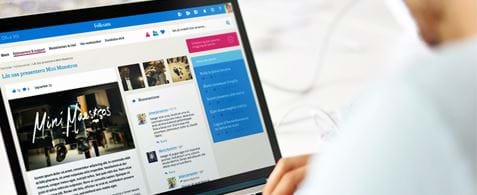 A laptop showing the Folksam intranet with a user's hands on the keyboard