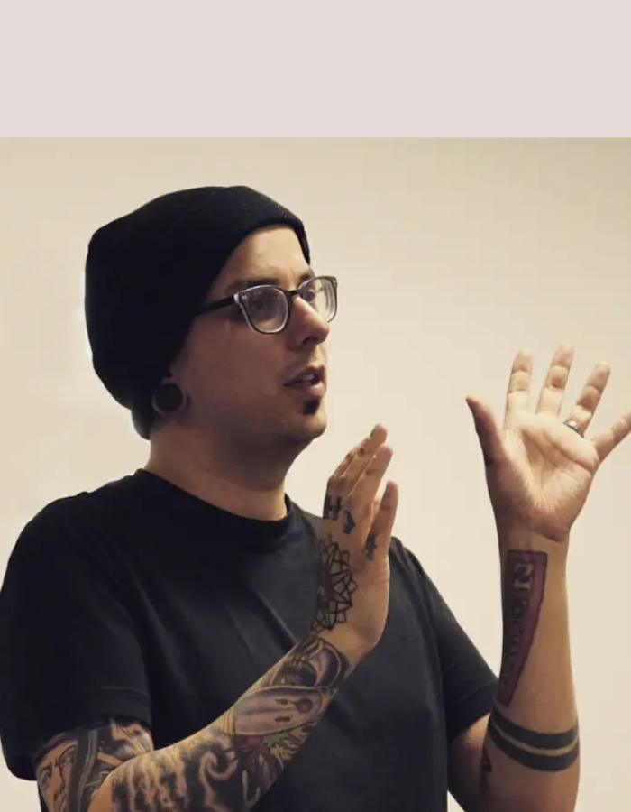 Headshot of Camp Digital speaker Dan Hett. Dan is wearing a black beanie and dark rimmed glasses.